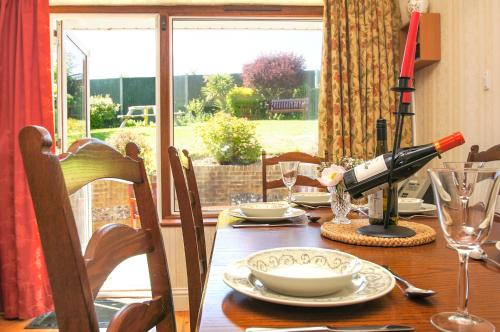 a dining room table with a bottle of wine on it at Dean Court Garden - Parking - by Brighton Holiday Lets in Rottingdean