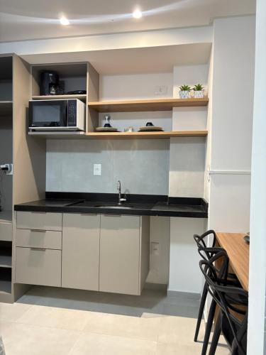 una cucina con lavello e microonde di Flat Moderno a 100m da Praia do Bessa a João Pessoa