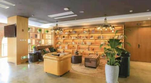 a large room with a library with a plant in it at James Joyce Coffetel Taizhou Jiangyan Bus Terminal in Magou