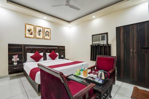 a bedroom with a bed and a table and chairs at Hotel Grand Lowsan Airport in New Delhi