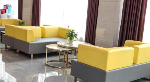 a waiting room with yellow chairs and a table at GreenTree Inn Express Yingtan Yujiang Railway Station in Yingtan