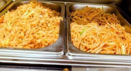 two metal trays of food with cheese and noodles at GreenTree Inn Express Yingtan Yujiang Railway Station in Yingtan