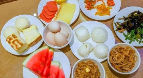 a table topped with plates of food with eggs and fruit at GreenTree Inn Express Yingtan Yujiang Railway Station in Yingtan
