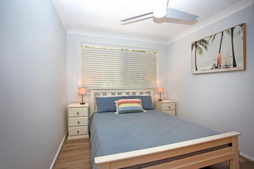 una camera da letto con un letto e due comodini di Mermaid Cottage a Hawks Nest