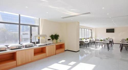 a large room with tables and chairs in a building at GreenTree Inn Express Zhangjiagang Hexing Town Shazhou Professional Institue of Technology in Qiwei