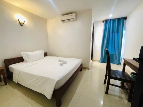 a bedroom with a bed and a chair and a desk at The Rabbit Hole Hotel Sok San in Siem Reap