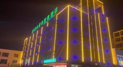 a large building with lights on it at night at GreenTree Inn Express Shandong Jinin Jiaxiang Railway Station in Jining