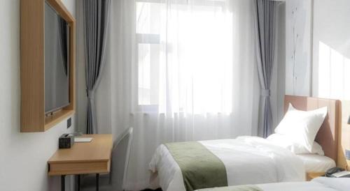 a hotel room with two beds and a window at GreenTree Inn Express Datong High-Speed Railway Station Old City Wall in Datong