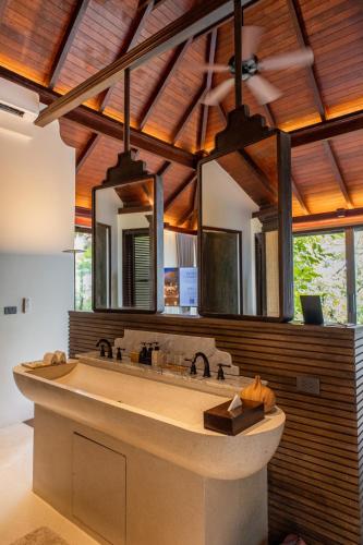 a bathroom with a large sink and a large mirror at Villa Zolitude Resort & Spa - SHA Extra Plus in Chalong