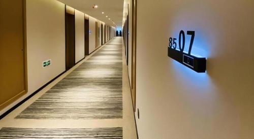 a hallway with a long aisle with a sign on the wall at GreenTree Inn Luoyang Railway Station Wangfujing Wangcheng Park in Luoyang