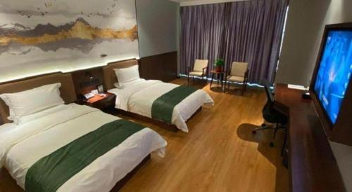 a hotel room with two beds and a flat screen tv at GreenTree Inn Express Datong High-Speed Railway Station Wanda Plaza Fangte in Datong