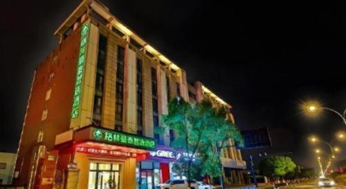 a building with a green sign on the side of it at Green Tree Inn Express Zhejiang Zhoushan Xincheng Zheda in Zhoushan