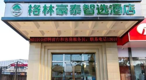 a restaurant with a sign on the front of a building at Green Tree Inn Express Zhejiang Zhoushan Xincheng Zheda in Zhoushan