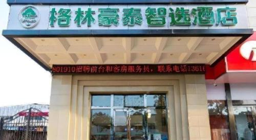 a restaurant with a sign on the front of it at Green Tree Inn Express Zhejiang Zhoushan Xincheng Zheda in Zhoushan