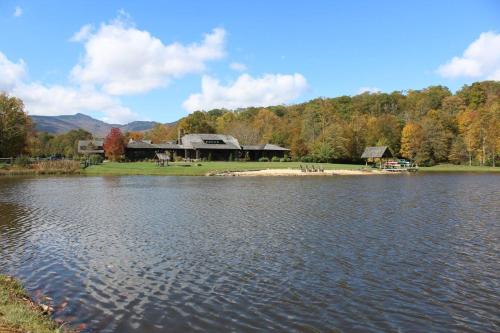 a view of a lake with a house in the background at Sweet Serenity at Sweetgrass in Blowing Rock