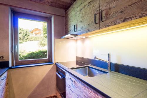 eine Küche mit einem Waschbecken und einem Fenster in der Unterkunft Etoile du Sud in Verbier