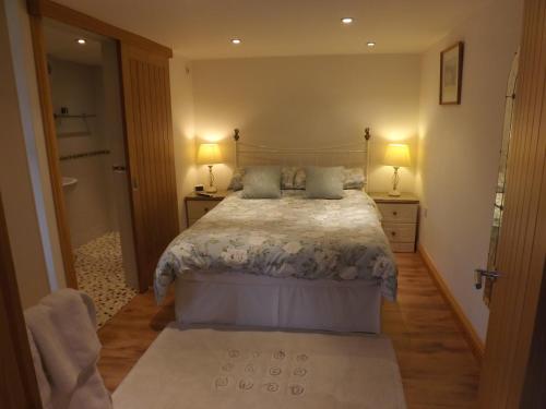 - une chambre avec un lit, deux lampes et une porte dans l'établissement Little Burbank, à Windermere