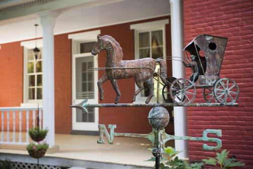a metal statue of a horse pulling a carriage in front of a house at Hollinger House in Lancaster