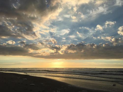 a sunset on a beach with the ocean at De Folks in Hoorn