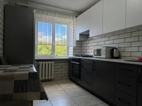a kitchen with a stove and a microwave in it at 2 к квартира в Чернівцях проспект Незалежності in Chernivtsi