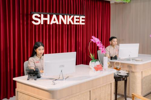 zwei Personen sitzen an einem Tisch vor einem Shanghai in der Unterkunft Shankee Sudirman Jakarta in Jakarta