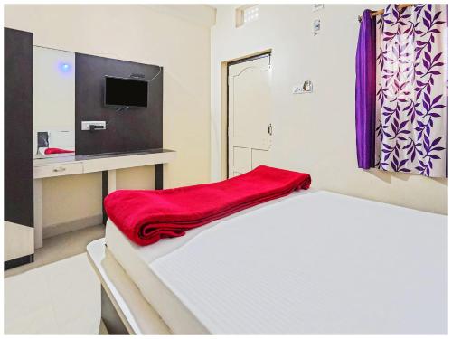 a room with a bed with a red blanket on it at Hotel Sea Scape Near Jagannath Temple in Puri