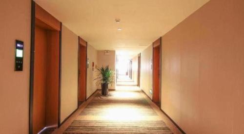 a hallway with a plant in the middle of a building at GreenTree Inn Luoyang Henan University of Science and Technology in Luoyang