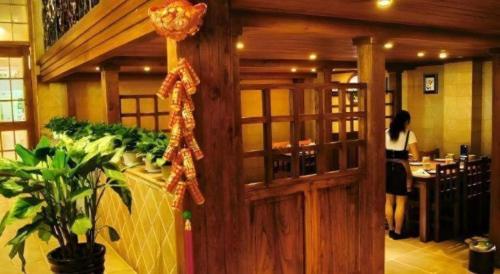 a woman standing behind a door in a restaurant at GreenTree Inn Luoyang Henan University of Science and Technology in Luoyang