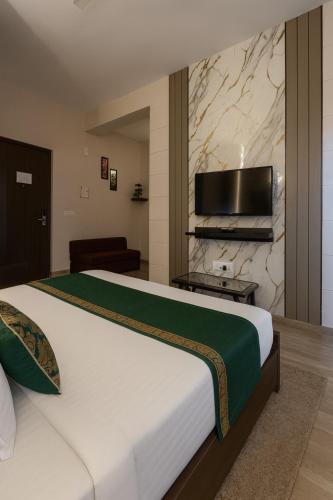a hotel room with a large bed and a flat screen tv at Hotel Citrine, Vrindavan - A Four Star Luxury Retreat # By Nandan Group # in Vrindāvan