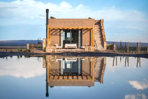 a house sitting on top of a body of water at Rosell Boher Winery Lodge & Spa in Agrelo
