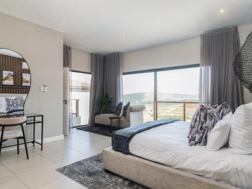 a bedroom with a large bed and a balcony at Zimbali Hills 8, Zimbali Estate by Euphoric Leisure in Ballito