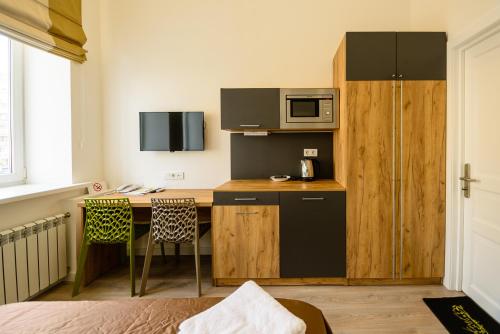 a small kitchen with a desk and a microwave at Partner Guest House Baseina in Kyiv