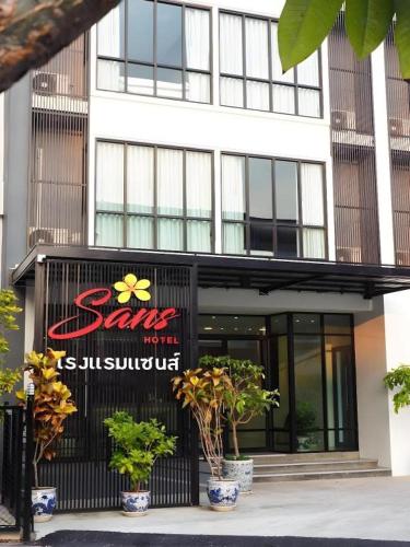 a restaurant with a sign on the front of a building at Sans Hotel in Ratchaburi