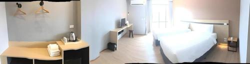 a room with a bedroom with a bed and a desk at Sans Hotel in Ratchaburi