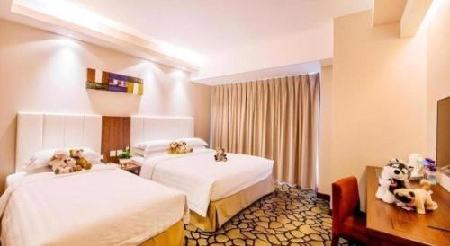 a hotel room with two beds with stuffed animals on them at OASIS AVENUE-A GDH HOTEL in Hong Kong