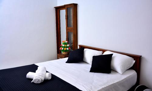 a bedroom with a large bed with black and white pillows at Angel Haven Villa in Mirissa