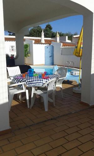 a patio with a table and chairs next to a pool at Villa Quica, heated pool in Albufeira