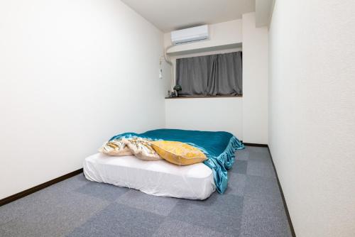 Shimo-mizoにあるZAMA Z-Styleの小さな部屋で、角にベッドが1台あります。