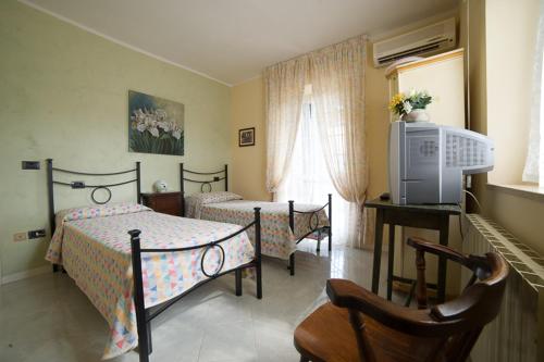 a bedroom with two beds and a television in it at Agriturismo Consalvi Valentina in Marsciano