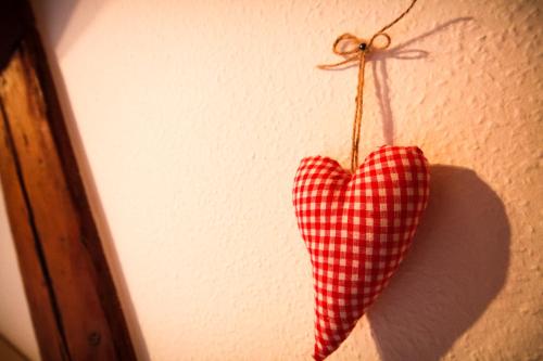 a red and white checkered heart hanging on a wall at Appartements Gahler - Kurort Oberwiesenthal in Kurort Oberwiesenthal