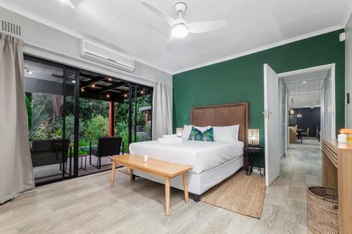ein Schlafzimmer mit einem weißen Bett und einer grünen Wand in der Unterkunft Bird of Paradise in Tzaneen