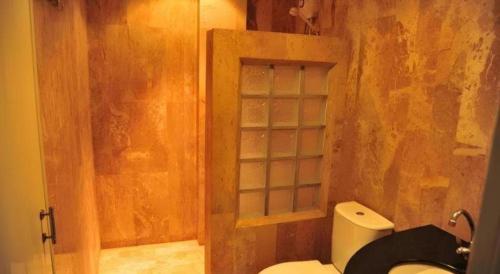 a bathroom with a toilet and a glass shower at Magic House Hostel in Hua Hin