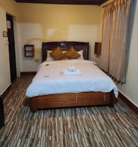 a bedroom with a bed with two towels on it at Luangprabang KhounPhet Guesthouse in Luang Prabang