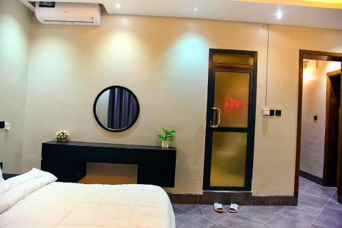 a bedroom with a bed and a mirror on the wall at Bhai Apartments in Mwanza