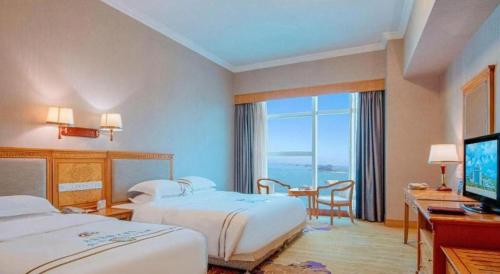 Ένα ή περισσότερα κρεβάτια σε δωμάτιο στο Zhuhai Dehan Hotel