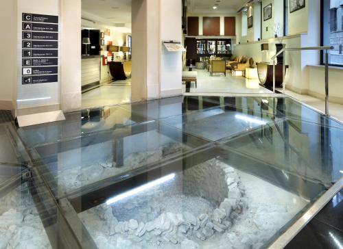 a glass floor with a fish tank in a lobby at Eurostars Gran Via in Granada