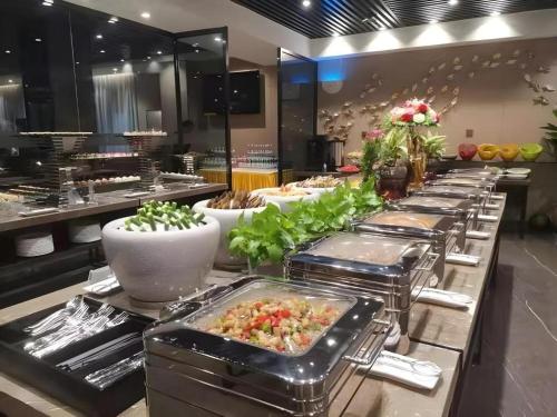 a buffet line of food in a restaurant at Shenzhen Hanyong Hotel Fuyong Branch in Shenzhen