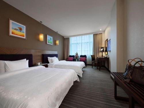 a hotel room with two beds and a desk at Shenzhen Hanyong Hotel Fuyong Branch in Shenzhen