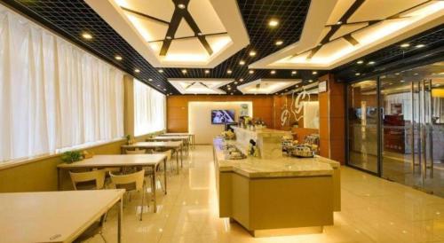 a restaurant with tables and chairs in a cafeteria at Jinjiang Inn Style Shenyang The Palace Huaiyuan Gate in Shenyang