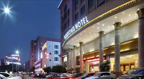 a parking lot with cars parked in front of a building at Shenzhen Hanyong Hotel Fuyong Branch in Shenzhen